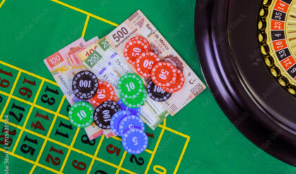 An casino roulette table with Mexican peso banknotes, poker chips is displayed on green gaming surface