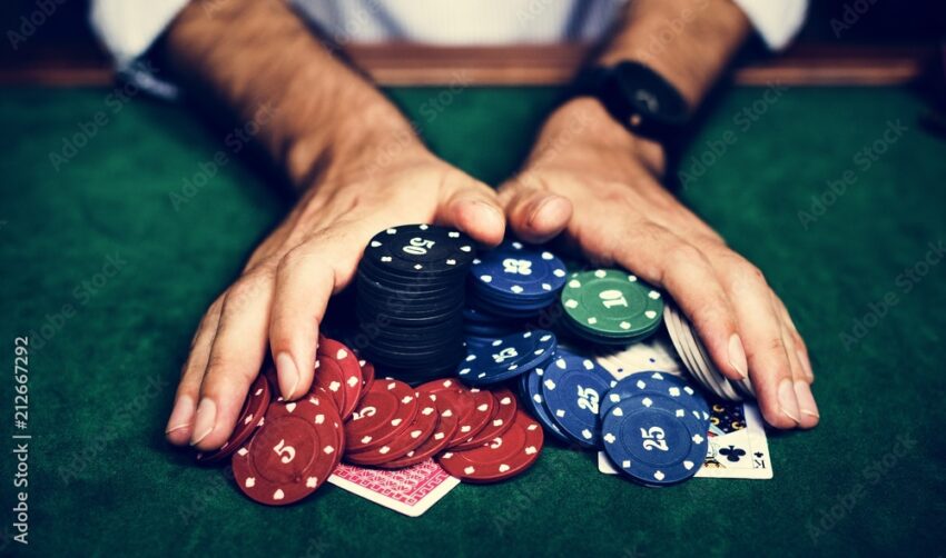 Closeup of hands with gambling tokens and card