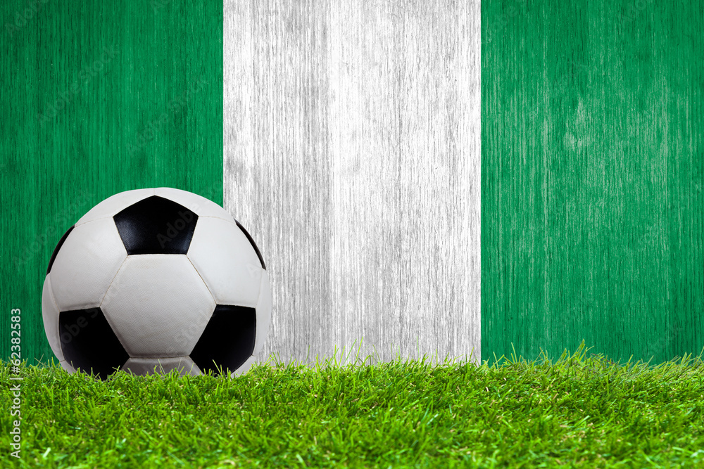 Soccer ball on grass with Nigeria flag background